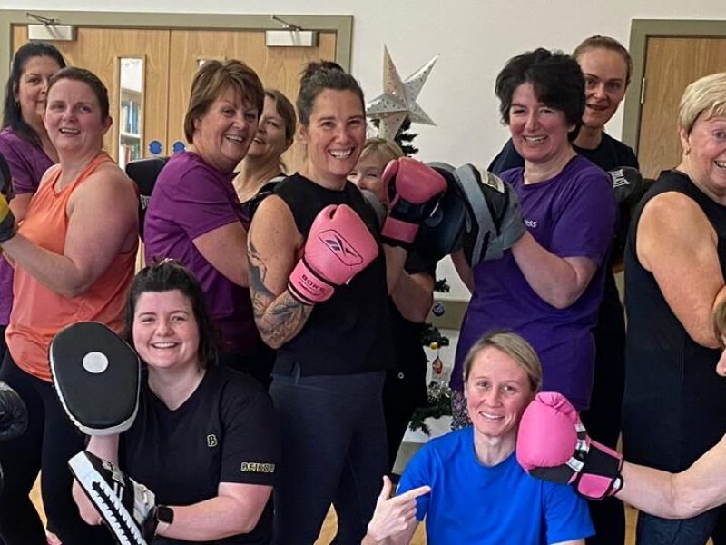 A group of women huddled together after a boxercise session.